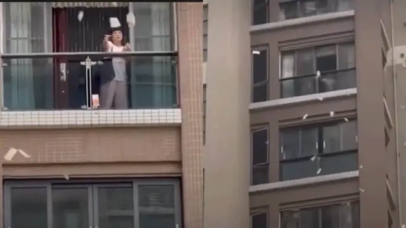 Chinese woman tosses out  ₹1.5 crore cash from balcony after argument with husband, residents gather to collect. WATCH