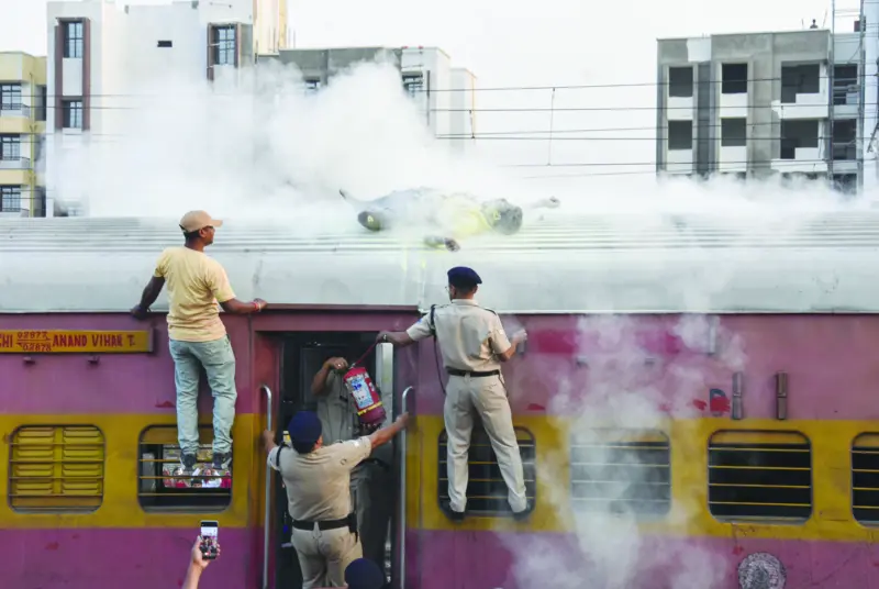 Railway Police Force (RPF) personnel use a fire extinguisher amid a rescue mission